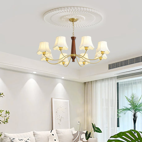 Chandelier lit in a pale living room above a sofa and a plant