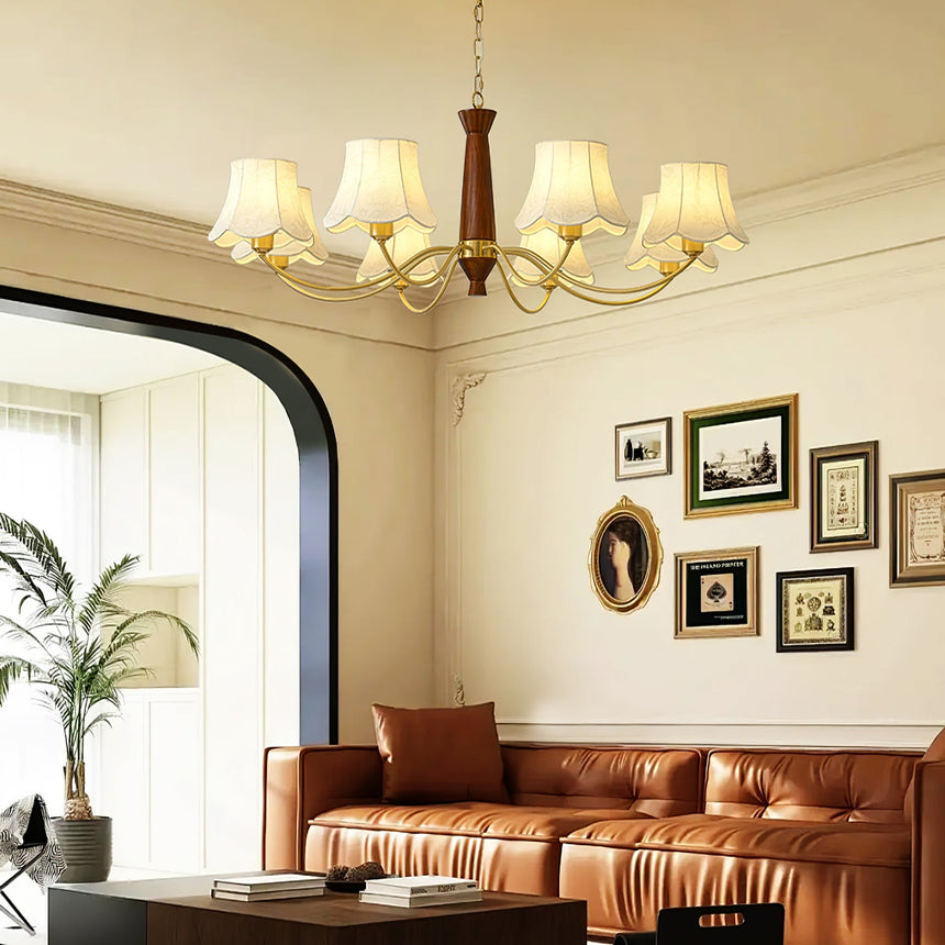The fitting lit above a tan leather sofa with framed pictures behind