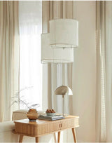 Linen drum pendant light beside a bedroom window with sheer curtains