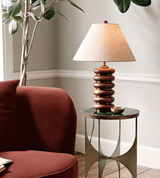Linen shade table lamp on a side table beside a deep red chair