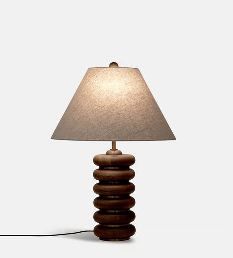 Close view of the lit linen empire shade above the wood rings