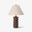 Linen shade table lamp on a column of stacked wood rings, plain ground