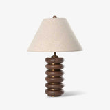 Linen shade table lamp on a column of stacked wood rings, plain ground