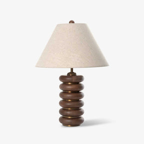 Linen shade table lamp on a column of stacked wood rings, plain ground