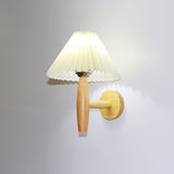 The round brass backplate with the oak arm rising from it to the shade