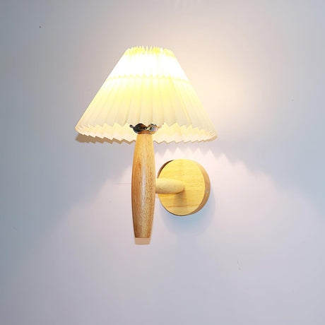 The pleated linen shade seen from the front above the turned oak arm