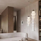 Stacked silk column hung beside a bed in a warm bedroom