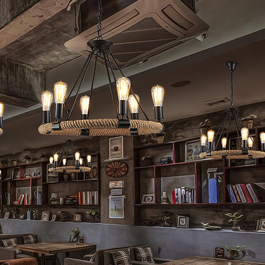 Chandelier lit in a room lined with shelves above a long table
