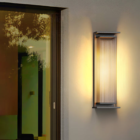 The light lit on dark cladding at a corner with a window beside it