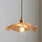The amber lotus shade seen alone against a plain pale background