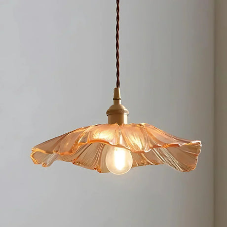 The amber lotus shade seen alone against a plain pale background