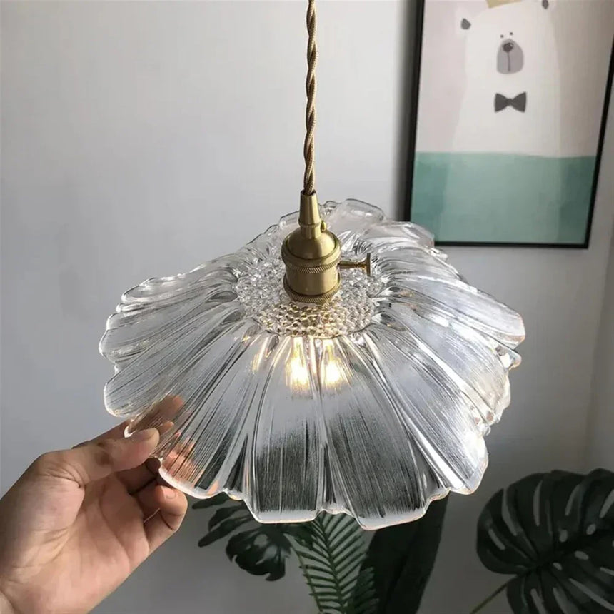 A hand holding the clear lotus shade to show how wide it is