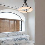 The lit ring above a marble bath under an arched window with blinds