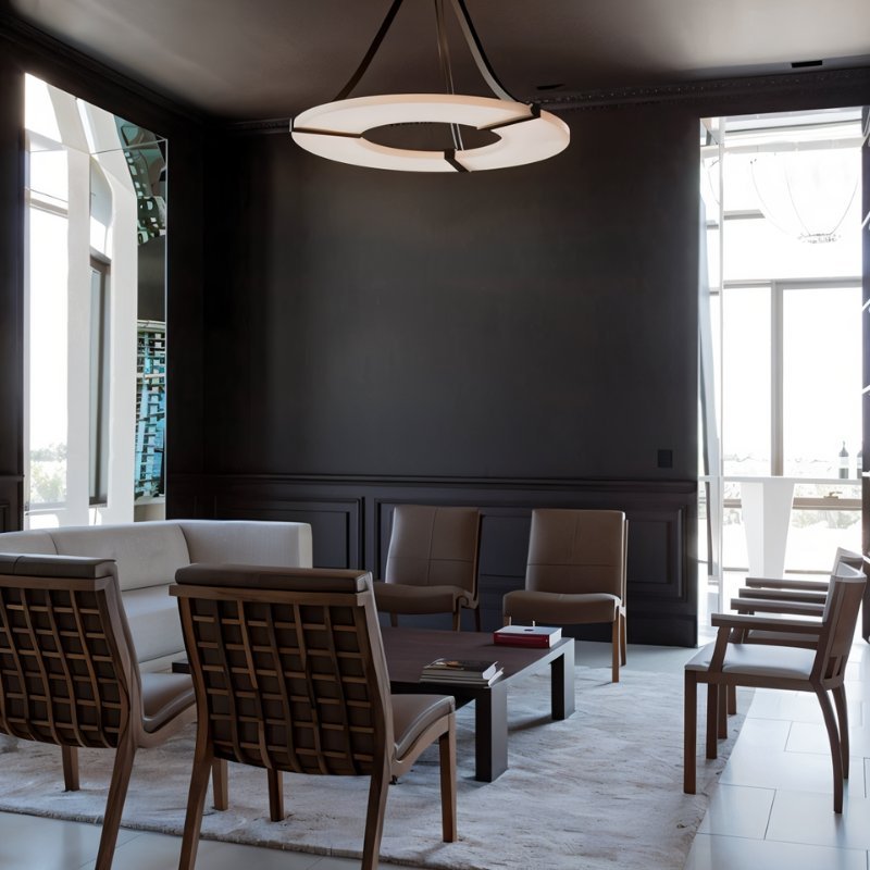 The lit ring in a dark dining room with chairs and tall windows behind