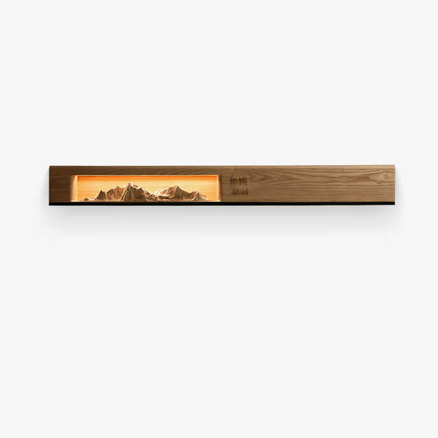Long light wood wall panel with a lit carved mountain scene inside