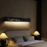 Black panel lit above a bed headboard between two table lamps
