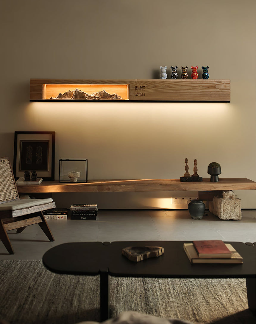 Light wood panel lit above a long wood table with small objects