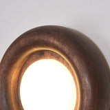 The lit diffuser glowing inside the curved inner face of the wood ring