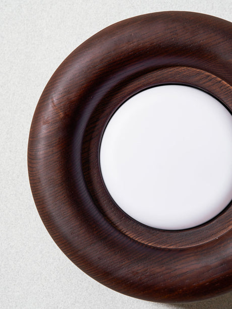 The turned grain running around the rounded rim beside the white diffuser
