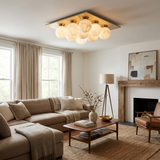 Nine ball alabaster ceiling light lit above a sofa near a fireplace and a floor lamp