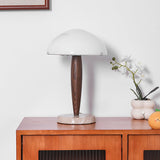 Marble base table lamp on a sideboard beside white orchids