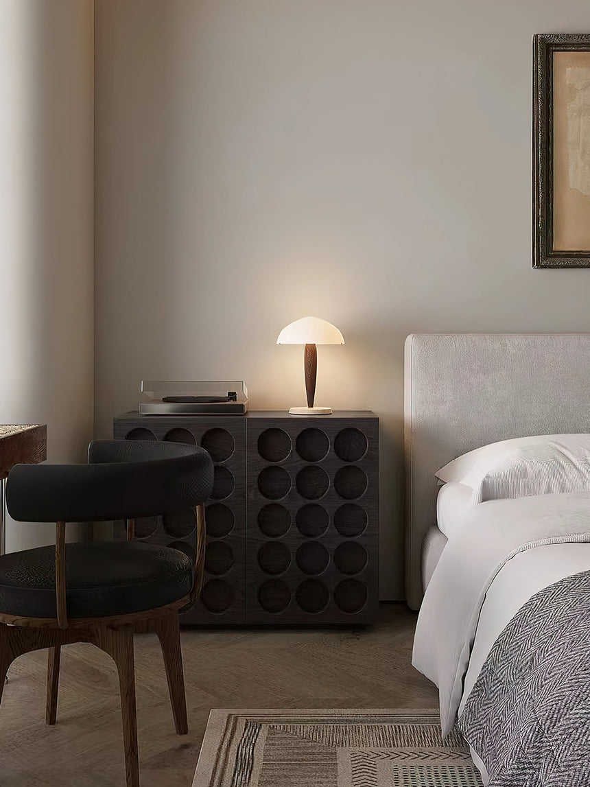 Marble base table lamp lit in a bedroom corner beside a bed