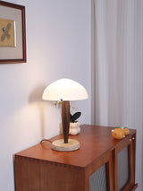 Marble base table lamp lit on a sideboard in a dim room