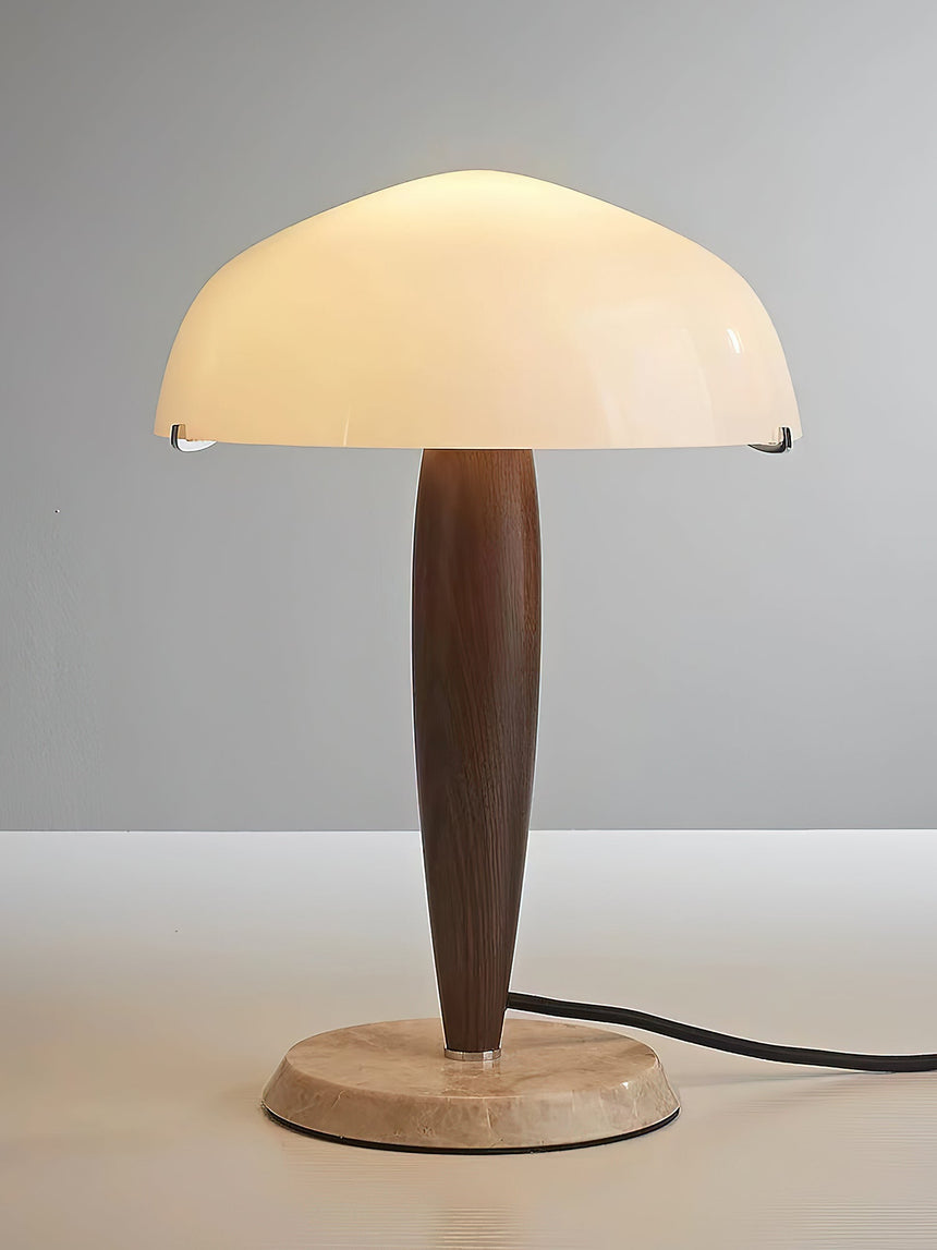 Marble base table lamp lit against a plain gray ground