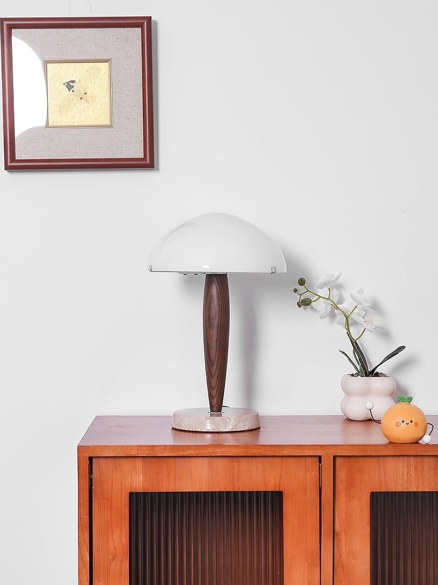 Marble base table lamp on a sideboard below a small framed picture