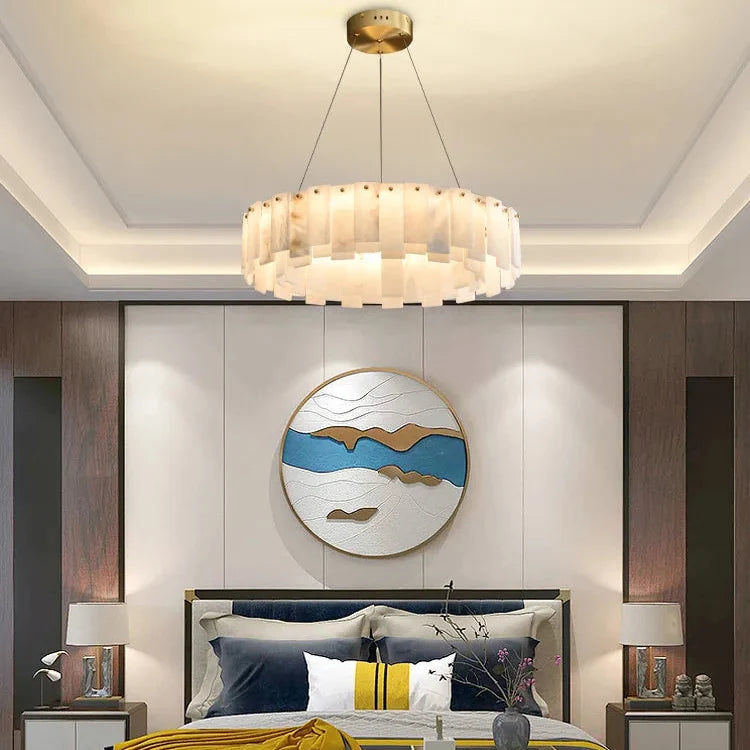 Marble ring chandelier above a bed in a blue bedroom