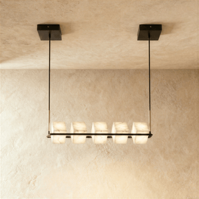 A long black bar carrying five lit alabaster cubes below a rectangular plate