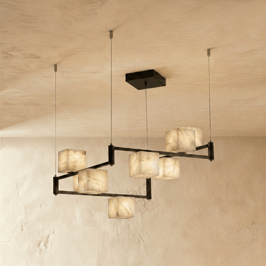 A wider staggered arrangement of lit stone cubes on black arms and cables