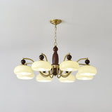 The turned walnut column and the brass collar the arms spring from
