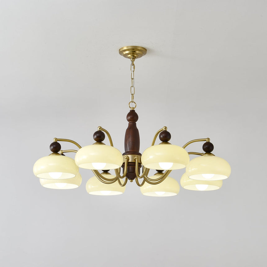 The turned walnut column and the brass collar the arms spring from