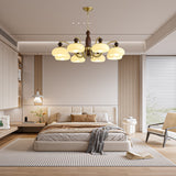 Chandelier lit in a bedroom above a made bed and two nightstands