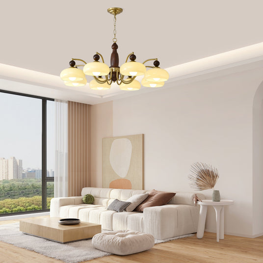 Chandelier lit above a cream sofa and a low table in a pale room