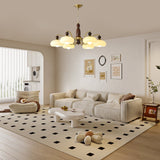 The fitting lit above a patterned rug and a pale sofa group