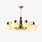 Mid century chandelier with brass arms and beige glass domes on walnut