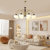Chandelier lit above a cream sofa and a round coffee table