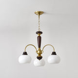 Chandelier lit warm, the opal globes glowing above a room corner