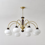 The white globes lit close, brass arms and walnut collars in view