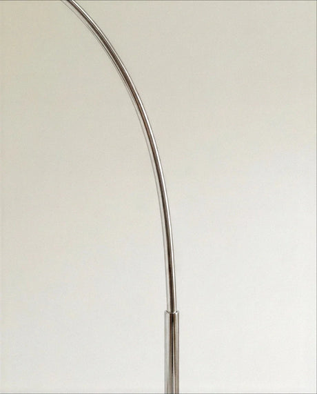 The polished chrome arm where it bends, showing the joint and the smooth finish