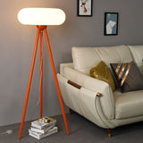 The orange lamp lit beside a cream sofa with cushions, framed pictures behind