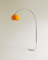 The same curved chrome arm with the orange glass dome, marble base on the ground