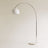 A curved chrome arm carrying a white glass dome above a round white marble base