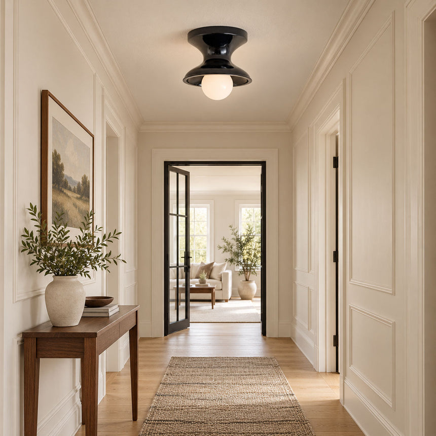 Navy spool ceiling light in a hallway with a console table and framed art