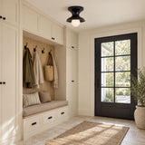 Navy spool ceiling light above a mudroom bench with coat hooks