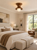 Red spool ceiling light above a bed beside a large window