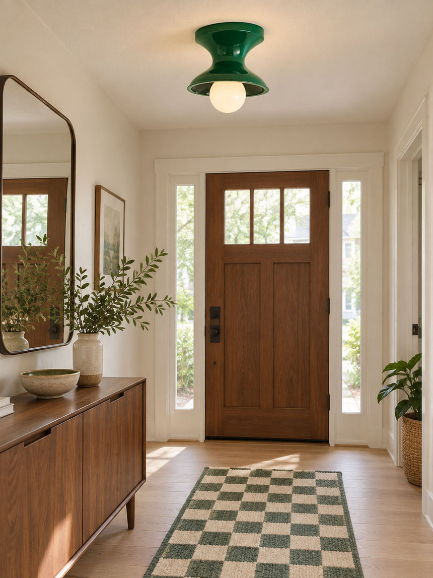 Green spool ceiling light in an entryway with a wood door and a sideboard