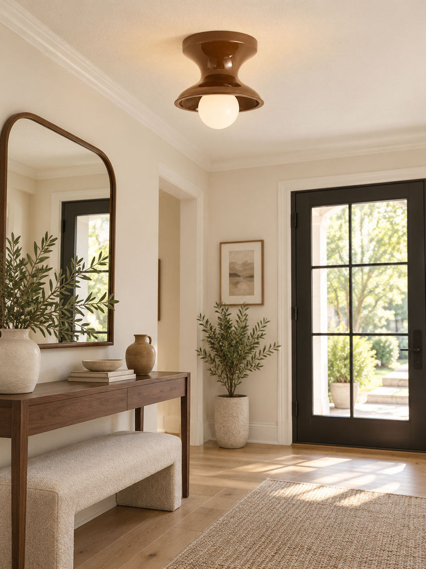 Red spool ceiling light in an entryway with an arched mirror and a bench